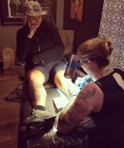 Photo by Kyle Zeiszler - Project Bike 2018 - Megan Hoogland documenting the Project on Dana's leg!