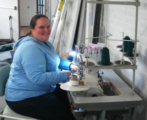 Photo by Don Lipps - Anna Knish, seamstress at Bumbelou in Mankato works on binding dresses.