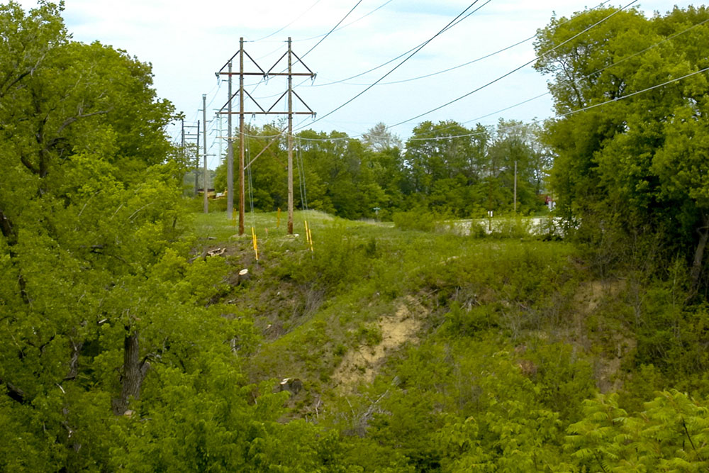 Photo by Rick Pepper - May 24, 2003 Looking north from the Madison East side of the ravine the bridge will span. These power lines will be a landmark in many of these photos, they run straight north-south across the ravine.