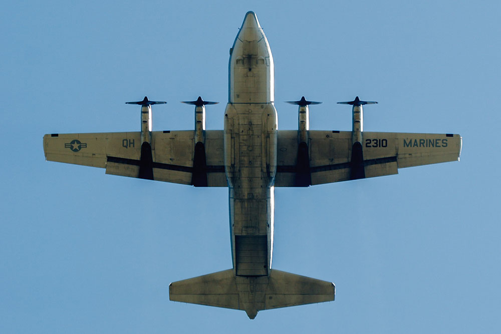 Photo by Rick Pepper - 2012 Mankato Air Show - The C-130 flies directly overhead before releasing the parachute jumper displaying the American flag.