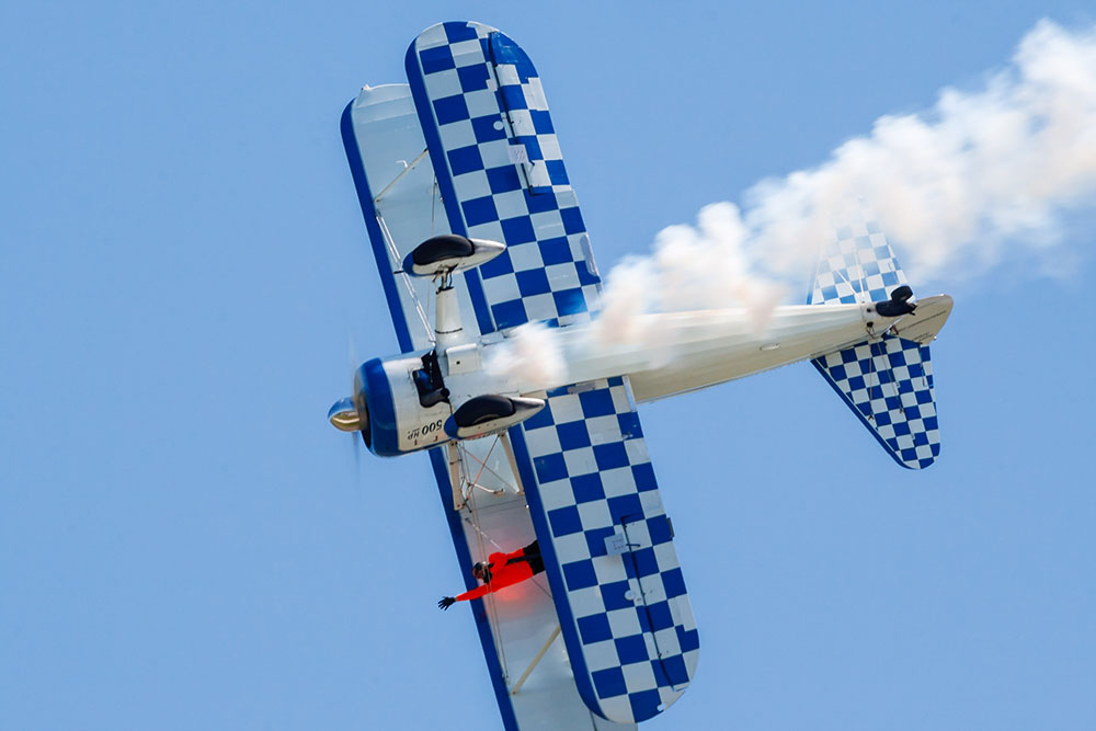 Photo by Rick Pepper - 2012 Mankato Air Show - Wing-walker Dave Kazian & stunt pilot Dave Dacy do a barrel roll in their Super Stearman