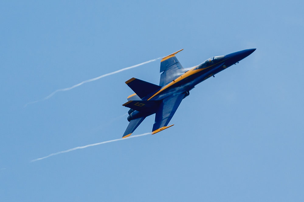 Photo by Rick Pepper - 2012 Mankato Air Show - The Blue Angel opposing solo aircraft executes a high-G turn creating vapor trails on its way back to the airshow