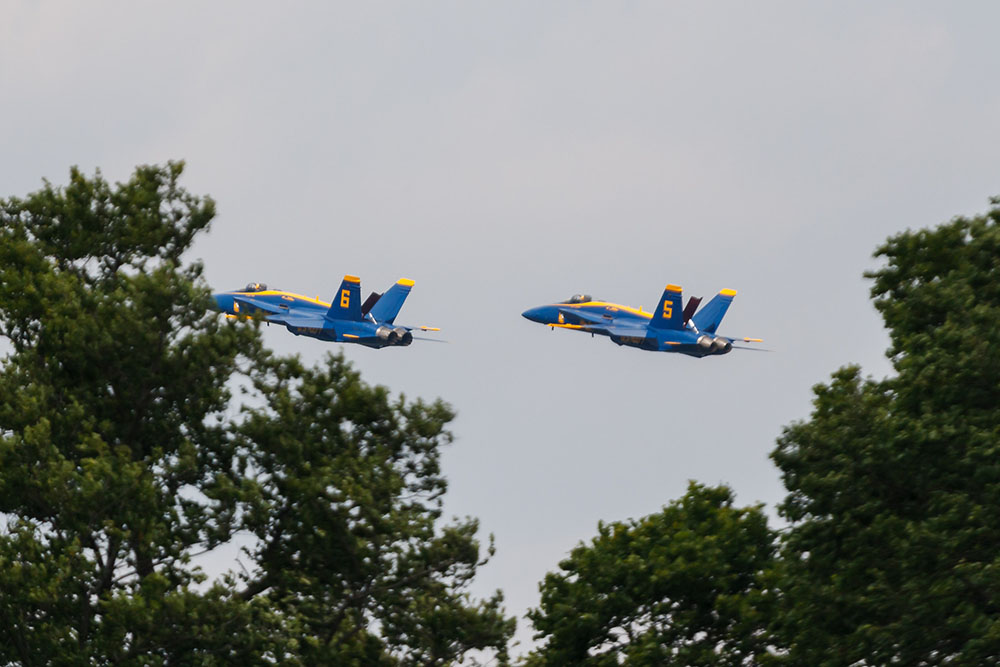 Photo by Rick Pepper - 2012 Mankato Air Show - The Blue Angel solo aircraft clear the tree tops approaching the airshow for a low speed pass demonstrating thrust-vectoring, allowing them fly at about 120 mph