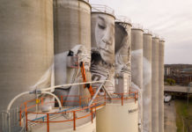 Photo by Rick Pepper - Aerial view of the in-progress Silo Art Project by Australian artist, Guido van Helten on the Ardent Mill grain silos at the gateway of Old Town, Mankato.