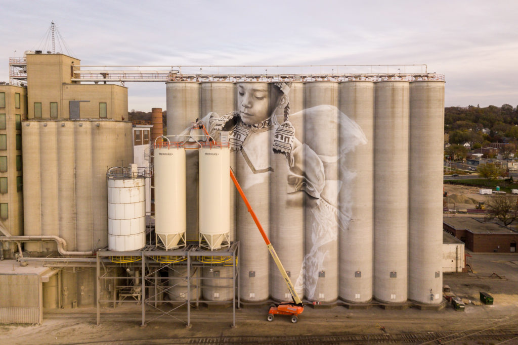 Photo by Rick Pepper - Aerial view of the in-progress Silo Art Project by Australian artist, Guido van Helten on the Ardent Mill grain silos at the gateway of Old Town, Mankato.