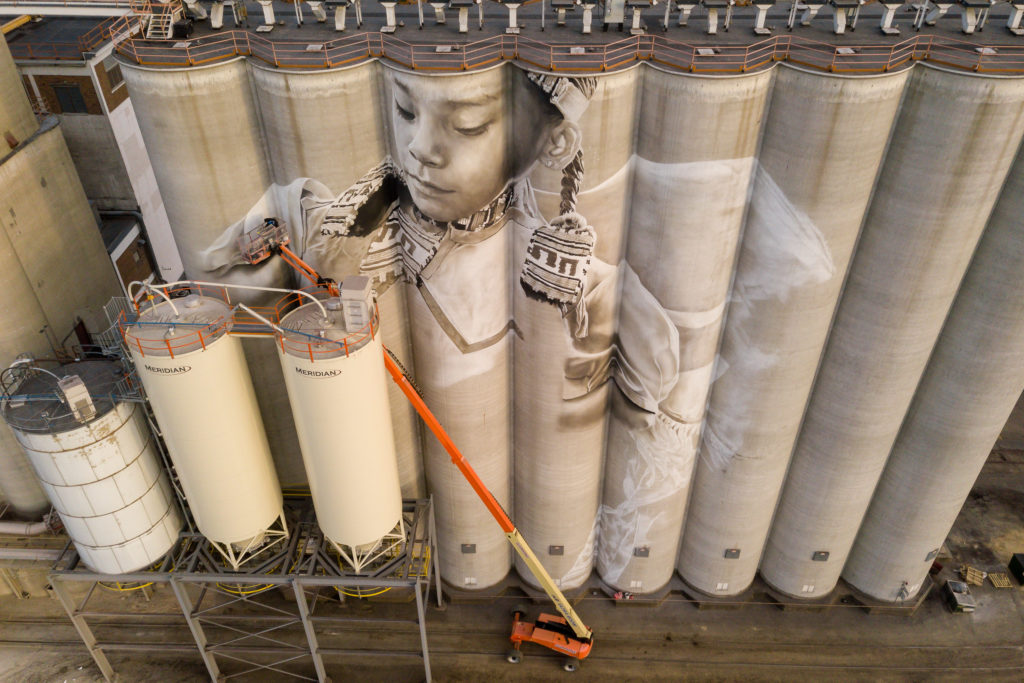 Photo by Rick Pepper - Aerial view of the in-progress Silo Art Project by Australian artist, Guido van Helten on the Ardent Mill grain silos at the gateway of Old Town, Mankato.