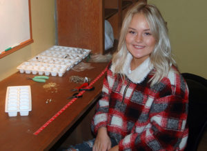 Photo by Don Lipps - Coral Bjork assisting resident artist, Ginger Neilan of Bobbles & Bobbies, by assembling earrings.