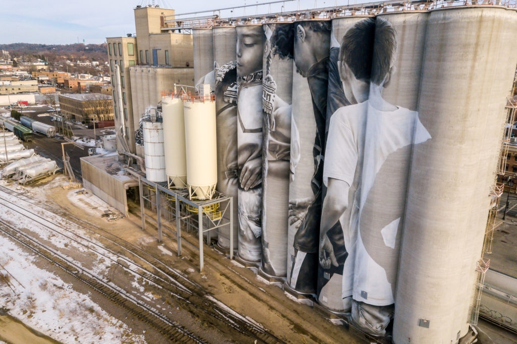 Photo by Rick Pepper - Aerial view of the in-progress Silo Art Project by Australian artist, Guido van Helten on the Ardent Mill grain silos at the gateway of Old Town, Mankato.