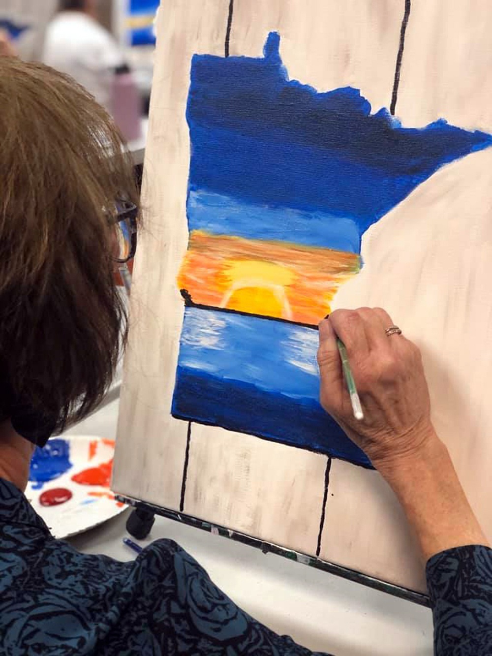 Submitted Photo - Participant painting Minnesota at a Design & Wine Workshop at Blue Earth County Library
