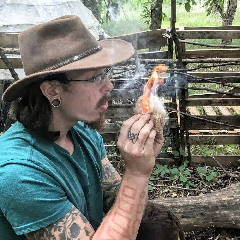 Submitted Photo - Mason Grove demonstrates blowing a tinder bundle into a flame