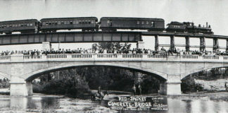 From History of the Red Jacket Valley by Julie A. Schrader - Panoramic view of the Red Jacket Bridge and Trestle by Mankato photographer, John R. Snow at the dedication of the bridge on August 22, 1911. Snow coaxed the train engineer into backing up so the camera could capture everything. He was credited with the first panoramic photograph taken in the Mankato area. Actually, the photograph is a composite of four photographs snapped from the same spot and then pieced together.