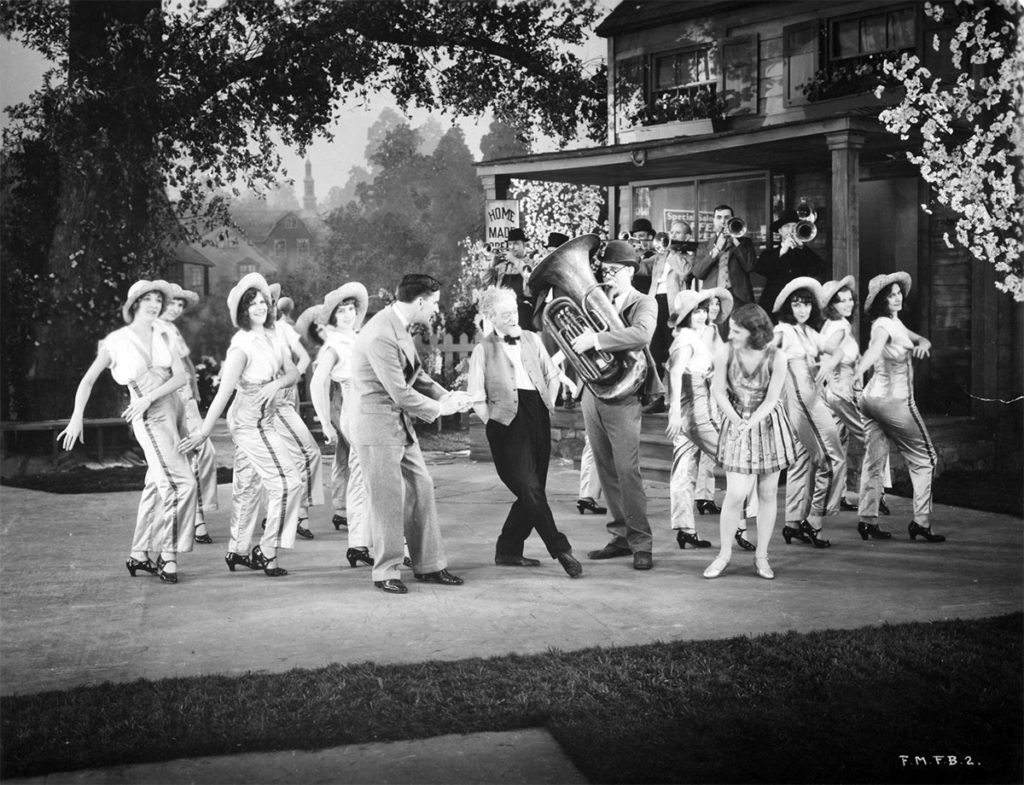 Photo courtesy Muriel Kuebler Berndt - Muriel and Barbara Kuebler in “50 Miles from Broadway,” one of the “short” pictures produced by Pathe Films to run in theaters between newsreels and the main feature. Barbara is third from the left and Muriel is to the immediate right of the tuba player.