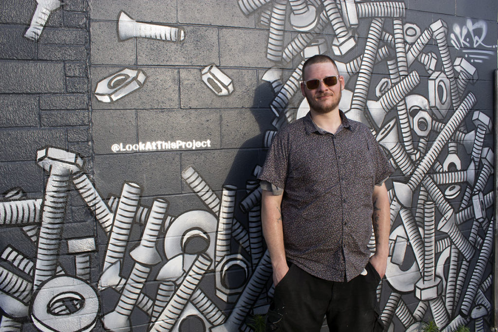 Photo by Rachael Jaeger - Kendrick Daum in front of his work on Rock Street Auto