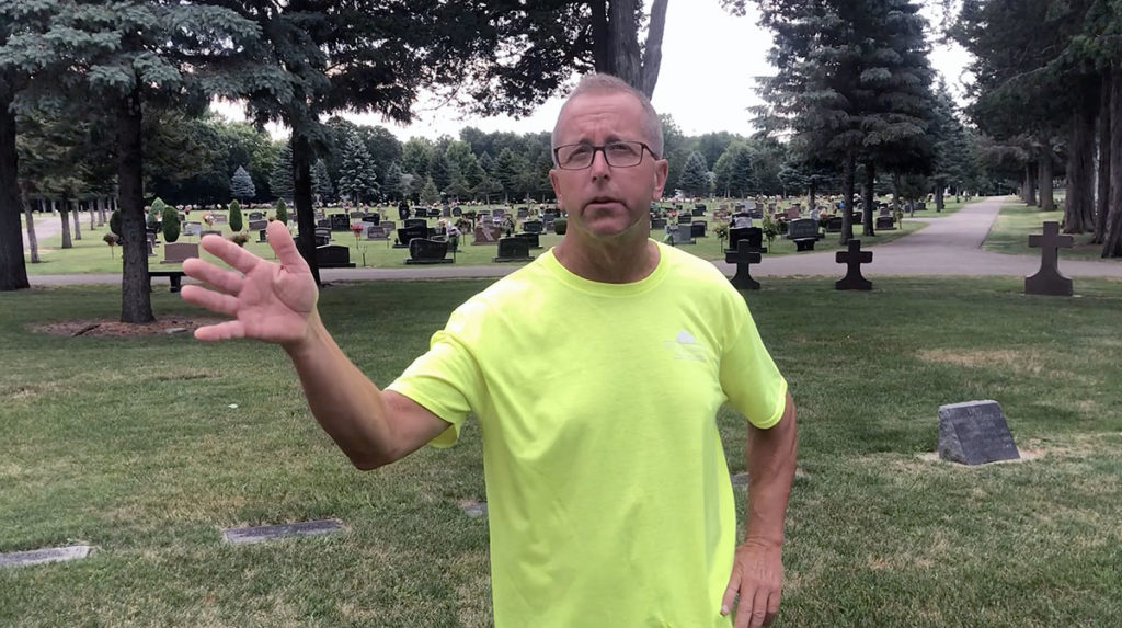 Photo by Mike Lagerquist - Caretaker Terry Miller stands outside the cemetery’s chapel, with headstones stretching out behind him. He took over from his father, Jerry Miller, when he retired in 1995.