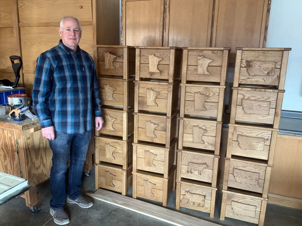 Submitted Photo - Tim Hatlestad of North Mankato in front of a selection of northern-themed outdoor planter boxes