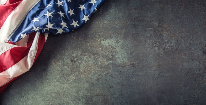 American flag on dark concrete with free space. 4th July Veterans or US Independence day.