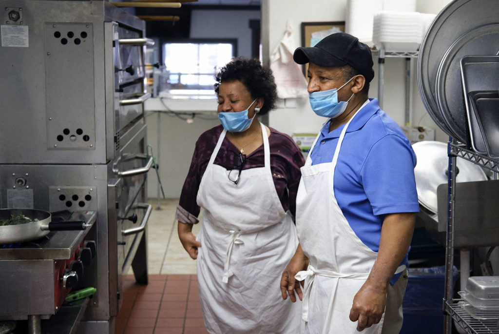 Photo by Casey Ek - Akberet and Hensta share a pleasant moment in the kitchen of Great New York Pizza. The siblings, who separately left Eritrea in response to domestic guerilla warfare in 1981 and 1994 respectively, now view the United States as their home.