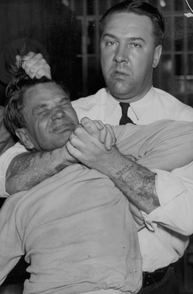 Photo Courtesy Hennepin County Library: Minneapolis Newspaper Photograph Collection - Tommy Gannon aressted July 1, 1935. Gannon held in a headlock by Patrolman Mickelson