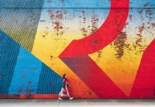 Young girl walking by wall with graffiti in New York